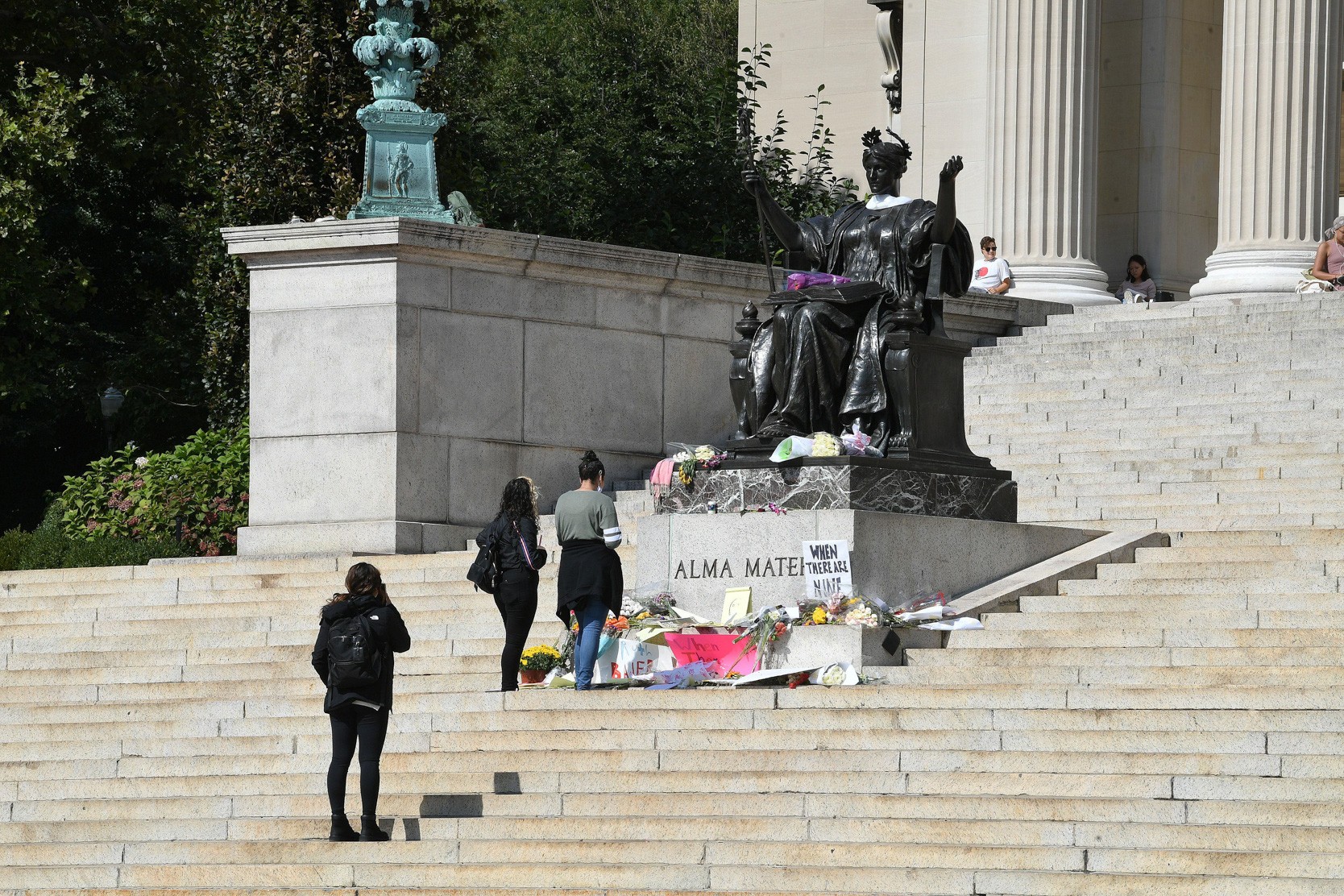 Columbia Community Members leaving flowers at the feet of "Alma Mater" in memory of Supreme Court Justice Ruth Bader Ginsburg