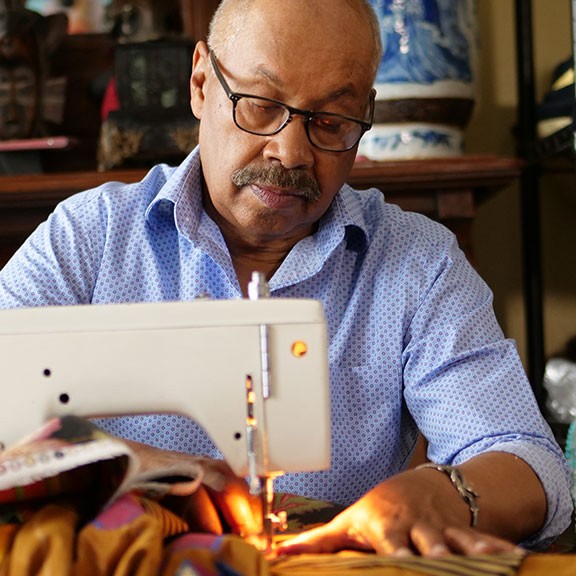 The artist Michael A. Cummings works at his sewing maching