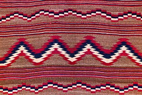 Unknown Diné (Navajo) maker, Child's banket (detail), 1879-80. Collection of Art Properties, Avery Architectural & Fine Arts Library.  This woven textile includes horizontal sections of alternating zig-zag patterns and stripes in red, white, and dark blue on a tan colored background
