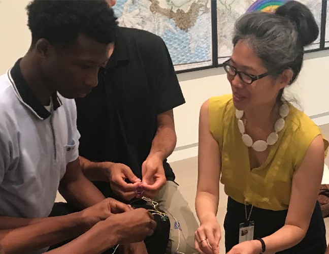 A group of students gathered in a circle with a gallery educator.