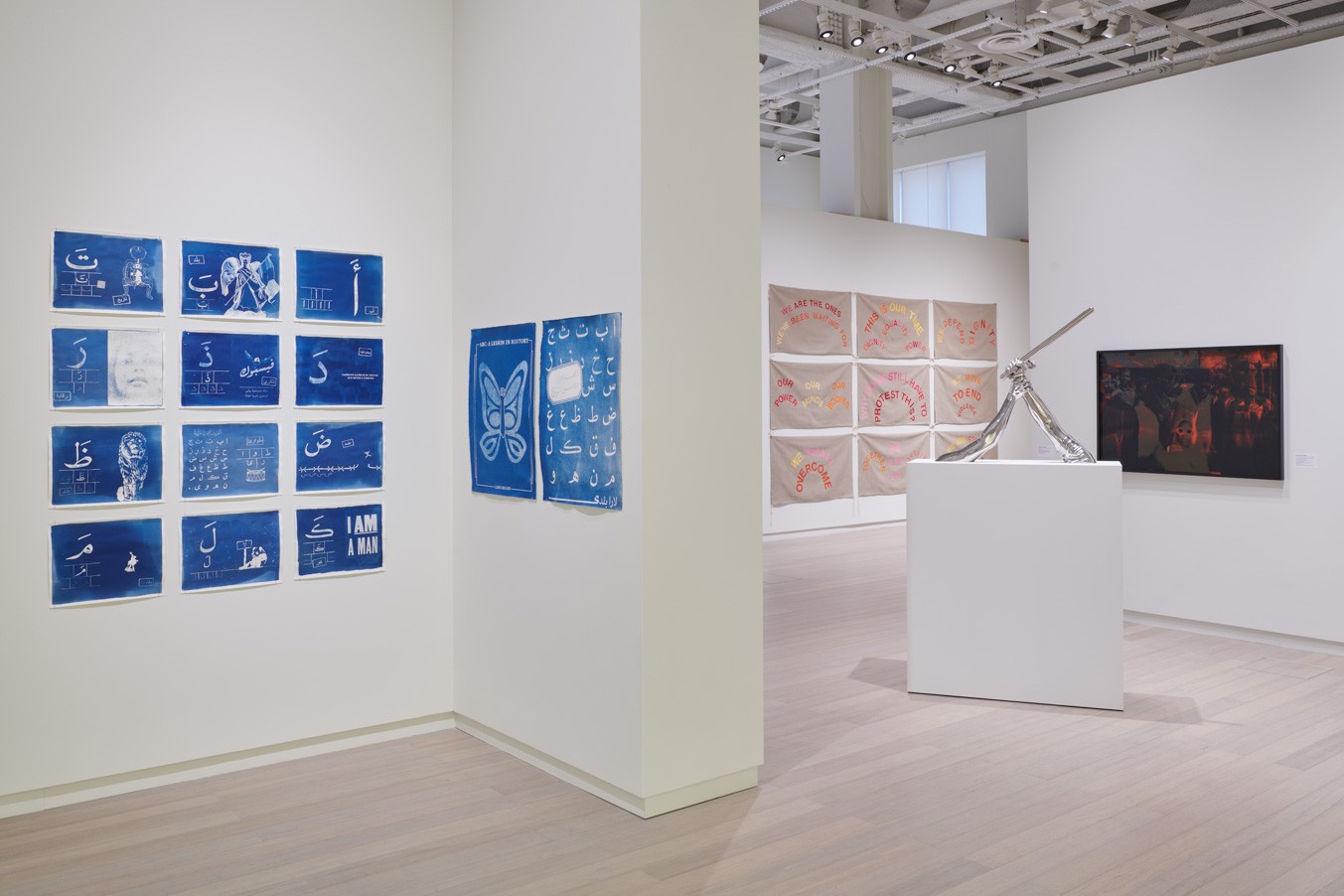 Installation view showing works by the artists Lara Baladi and Hank Willis Thomas from the exhibition “The Protest and The Recuperation” on view at the Wallach Art Gallery, Columbia University. Photograph by Kyle Knodell.