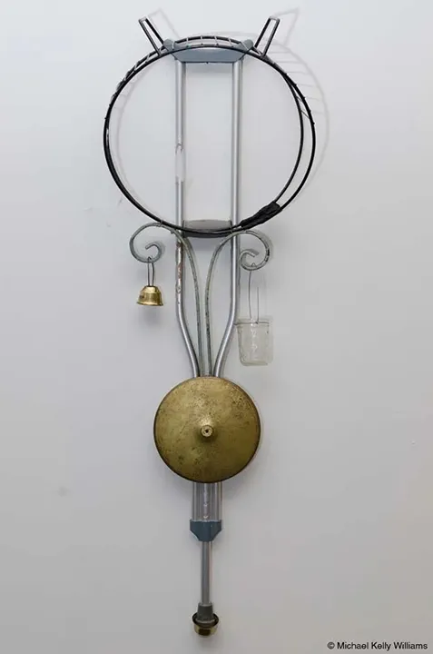 Michael Kelly Williams, Meditations, 2016. Brass bell, water glass, Cinefoil, aluminum crutch with plastic and rubber elements, wire, wrought iron scrolls, brass cymbal, and circular steel magazine rack stand. 48 × 16 × 12 in.