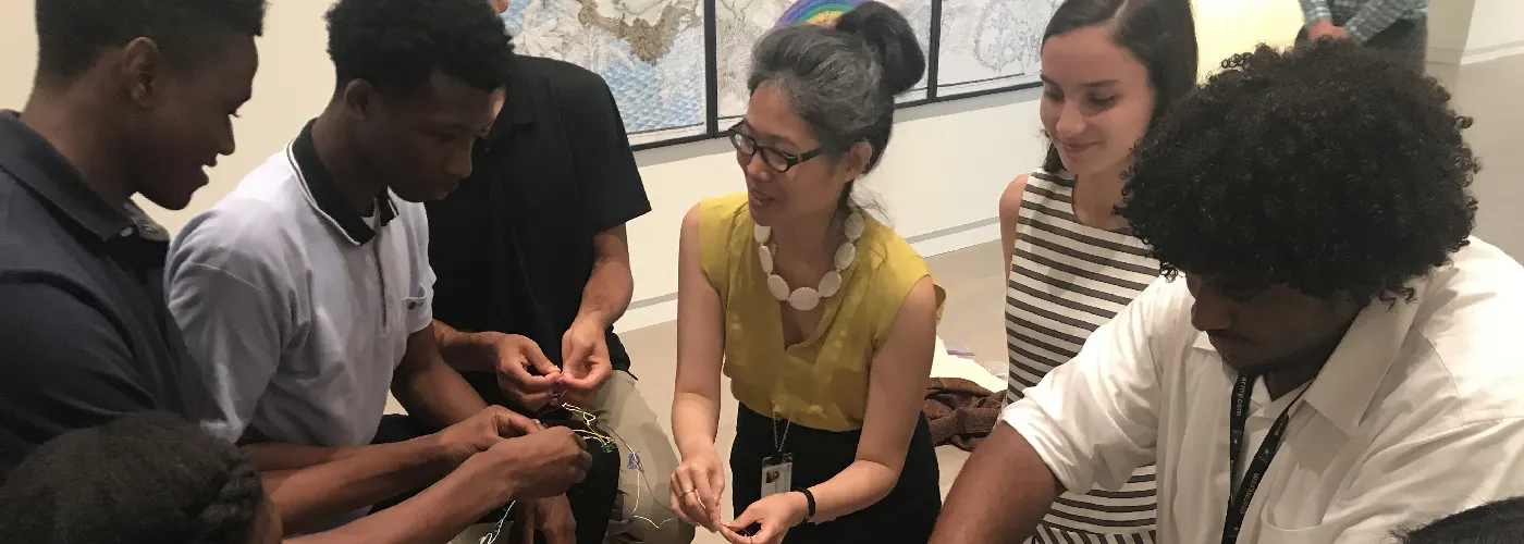 A group of students gathered in a circle with a gallery educator.